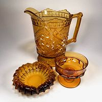 Group view of amber glass pitcher, compote and ashtray