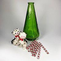 Group shot of green glass decanter, two ceramic cat shakers, ten glass swizzle sticks