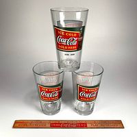Three Coca-Cola tumblers stacked with ruler