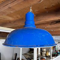 Side view of blue metal pendant shade hanging from ceiling