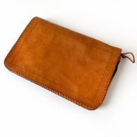 Front view of brown leather folio showing whipstitch edges