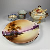 Group shot of plate, sugar bowl with lid and spoon, two cups