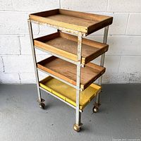Front angled view of entire cart showing all four tiers and casters