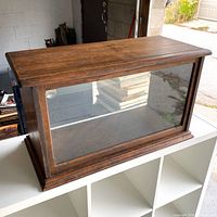 Front view of wooden display case with glass front
