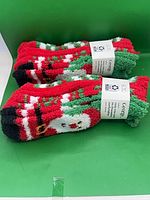 Two bundled packs of George brand Christmas crew socks showing Santa design and labels