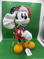 Front view of Mickey Mouse figurine holding Christmas lights