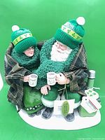 Front view of Santa and Mrs. Claus figurine with mugs, blanket, hats, tags visible