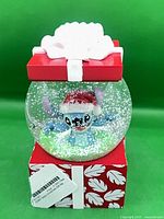 Front view of Stitch snow globe on gift-box base