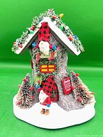 Overall view of snow-covered gnome house figurine on white base