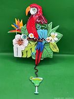 Full view of parrot wall clock showing colours, foliage and pendulum