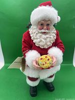 Front view of Santa figurine holding cookie, hang tag visible