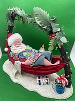 Full view of Santa in hammock between palm trees on sand base