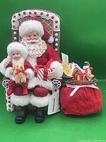 Full view of Santa figurine seated on gingerbread chair with accessory sack