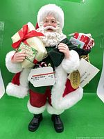 Front view of Santa figurine with gifts and tags