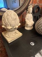 Finial and figurine on shelf