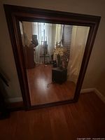 Full view of rectangular mirror leaning against wall