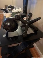 Large glossy black jack and matching ball on tabletop
