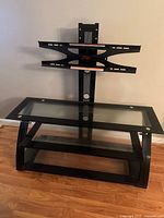 Front view showing three glass shelves, metal frame, and mounted bracket