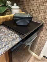 Black square bowl atop plates
