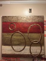Front view of abstract canvas with raised rings and horizontal color bands