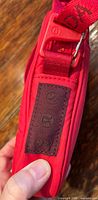 side view of red Lululemon bag showing logo patch and buckle