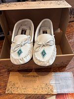Top view of moccasins in original box with authenticity sheet