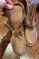 Top view showing both boots, laces, leather texture, Roots logo on tongue