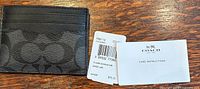 Front of Coach signature card case with tags and booklet