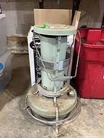 Full view of Aladdin heater showing pale green cylinder, base, and metal guard