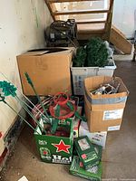 Pile showing tree stand, yard stakes, boxes, bins with tree parts and lighting