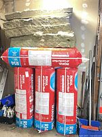 Three sealed Roxul ComfortBatt R14 bales with five loose batts stacked on top