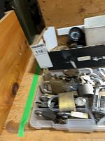 Tray containing multiple padlocks, keys and box with additional hardware
