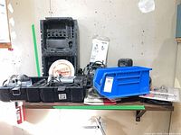 Shelf with open Porter-Cable router kit case, drywall cut-out tool, blue bin holding accessories