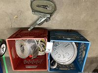 Red and blue milk crates holding ratchet strap, nylon tow strap, Cyclone hoist lid visible