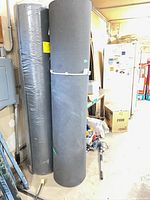 Two vertical grey foam rolls beside shelves and fridge