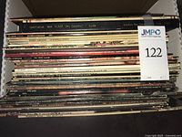 Box containing stack of vinyl LPs, spines visible