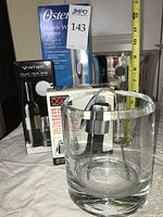 All items grouped: boxed Vinturi aerator, boxed Oster opener, boxed OGGI stoppers, glass ice bucket with tongs, stainless chiller bucket