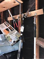 Group of garden tools hanging: hedge shears, loppers, pole pruning saw, gutter wand, Worx GutterPro box