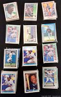 Twelve stacks of sleeved baseball cards arranged in grid