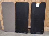 Three folded tables standing upright