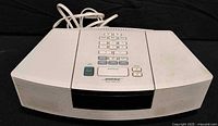 Front and top view of Bose Wave Radio/CD showing speaker grille and attached power cord