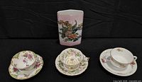 Group shot of three cup-and-saucer sets and pink peacock vase