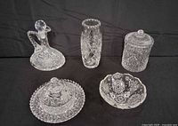 Five pieces grouped: cruet, vase, lidded jar, lidded dish, bowl