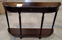 Front view of dark wood console table showing drawer, legs, lower shelf