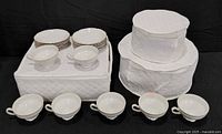 All dinnerware pieces packed in quilted storage cases; six tea cups displayed in front
