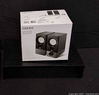 Front view of boxed Edifier R19U speakers placed on shelf