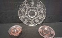clear etched plate and two pink Depression glass pieces