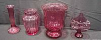 All four cranberry-pink glass pieces front view