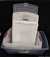 stacked view of blue tote body holding assorted lids showing colors and latch types