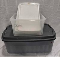 Large grey Rubbermaid tote with lid, clear tote and extra lids stacked